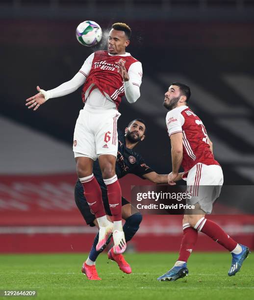 Gabriel Magalhaes of Arsenal heads the ball away from Riyad Mahrez of Man City as Sead Kolasinac looks on during the Carabao Cup Quarter Final match...