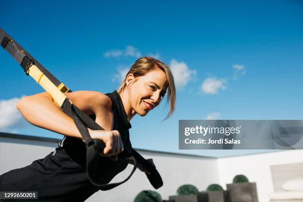 woman working out with straps - correa accesorio personal fotografías e imágenes de stock