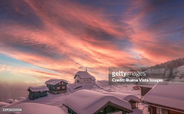 snow covered alpine village - schweiz stadt stock-fotos und bilder