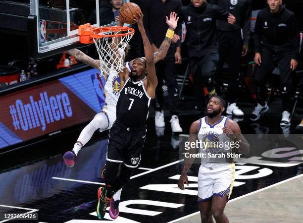 Kevin Durant of the Brooklyn Nets dunks as Kelly Oubre Jr. #12 and Eric Paschall of the Golden State Warriors defend during the first half at...