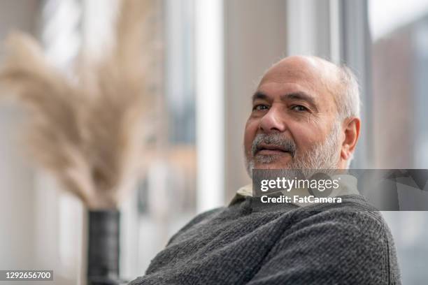 senior man relaxing at home - old arab man stock pictures, royalty-free photos & images