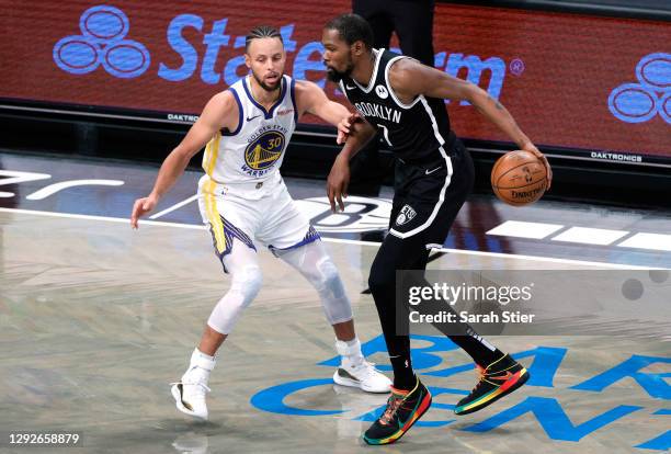 Kevin Durant of the Brooklyn Nets dribbles against Stephen Curry of the Golden State Warriors during the first half at Barclays Center on December...