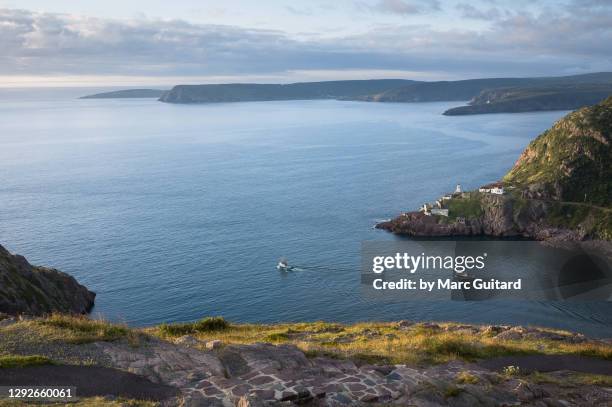 boats passing by fort amherst lighthouse, st. john's, newfoundland & labrador, canada - osten stock-fotos und bilder