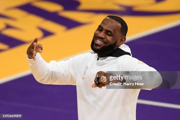 LeBron James of the Los Angeles Lakers reacts after receiving his 2020 NBA championship ring during a ceremony before the opening night game against...