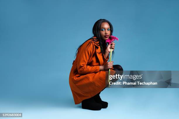 beautiful woman holding pink flower - art modeling studio stock-fotos und bilder