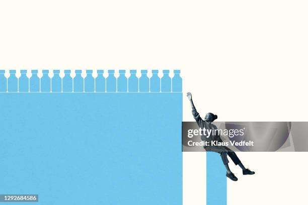 woman on blue column reaching for medicine bottles - studio shot stock-fotos und bilder