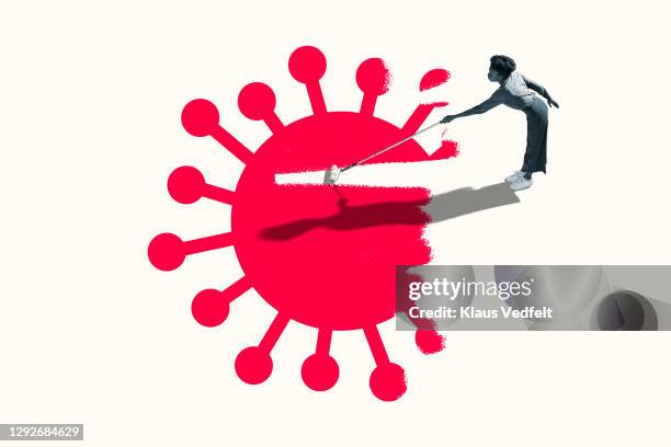 woman erasing red covid-19 virus with paint roller - coronavirus 2019 stock pictures, royalty-free photos & images