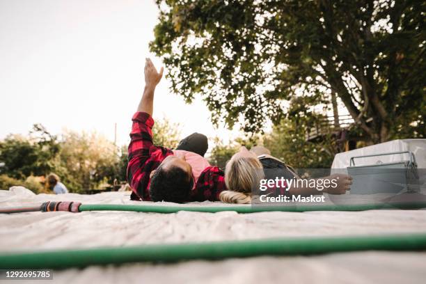 man with arms raised resting by partner after renovating during summer - backyard renovation stock pictures, royalty-free photos & images