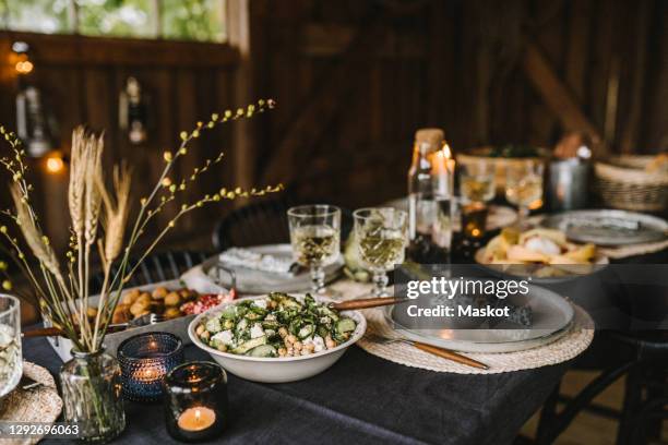 food in bowl by plate and drinking glass arranged on dining table during social gathering - candle light dinner stock pictures, royalty-free photos & images