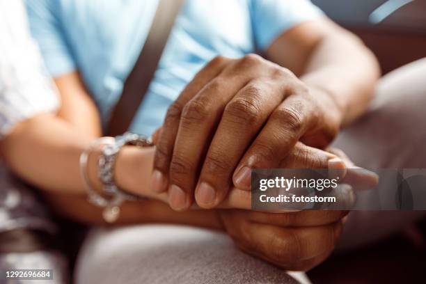 mixed race couple holding hands while traveling - holding hands in car stock pictures, royalty-free photos & images