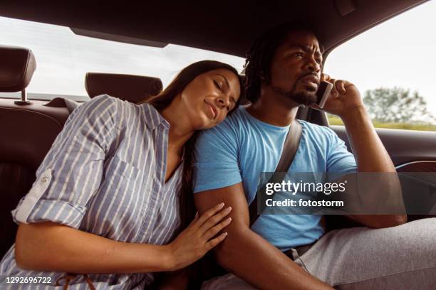 jeune femme dormant sur l’épaule de son copain tout en voyageant dans une voiture - couple sleeping in car photos et images de collection