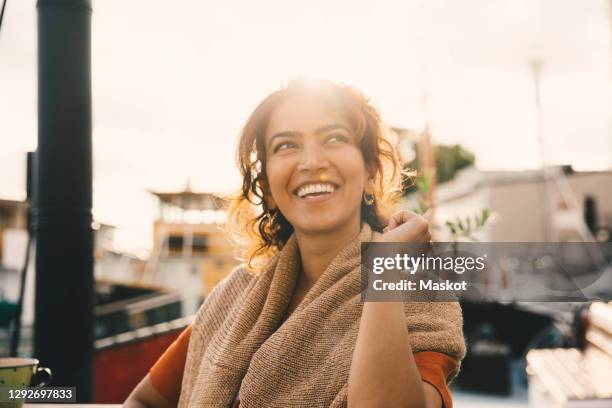 smiling woman looking away in houseboat - mujer feliz sola 30 35 fotografías e imágenes de stock