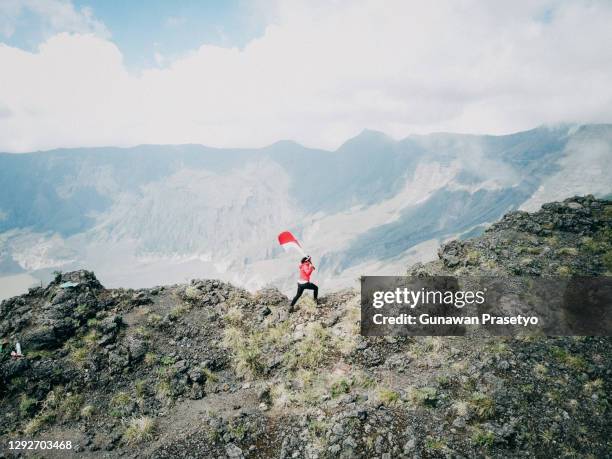 women running on top of mountains carrying indonesian flags - mountain peak with flag stock pictures, royalty-free photos & images