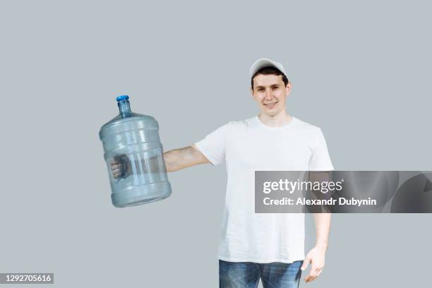 man courier holding water bottle holds in his hand - gallon fotografías e imágenes de stock