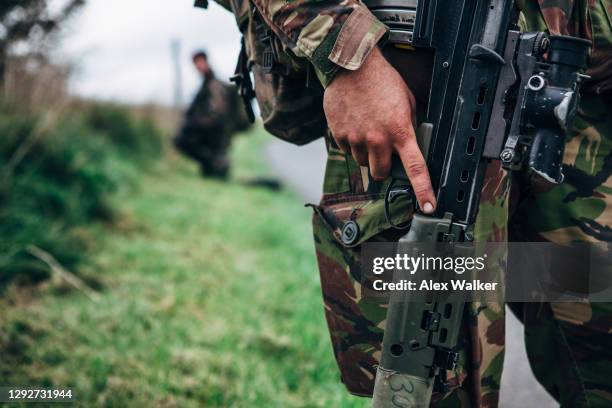close up of soldier holding assault rifle - waffe stock-fotos und bilder