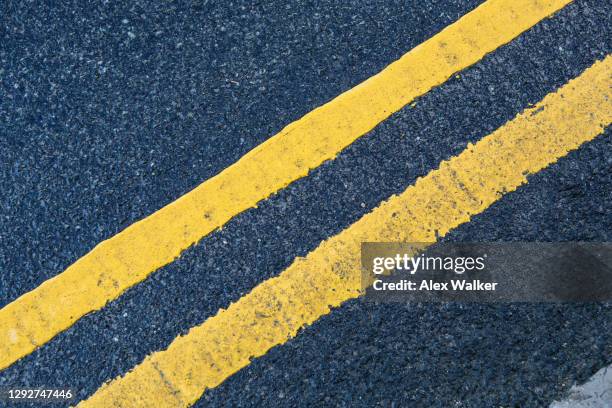 double yellow lines road marking on dark asphalt. - linea gialla foto e immagini stock