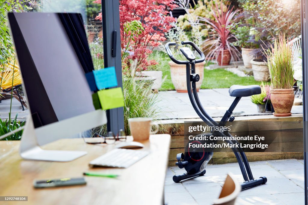 Desk in home office and exercise bike