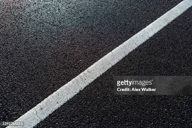 white line road marking on dark tarmac - rak bildbanksfoton och bilder