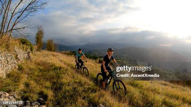 mountainbiker fahren morgens durch die wiese - fahrrad grün stock-fotos und bilder
