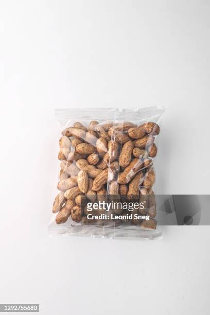 food photography of clean transparent plastic peanut pack top view on a light gray background isolated close up - peanut crop stock pictures, royalty-free photos & images