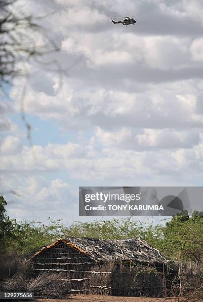 Kenyan military helicopter hovers over a village near Liboi township, on Kenya's border with Somalia on October 15, 2011 during a search for two...
