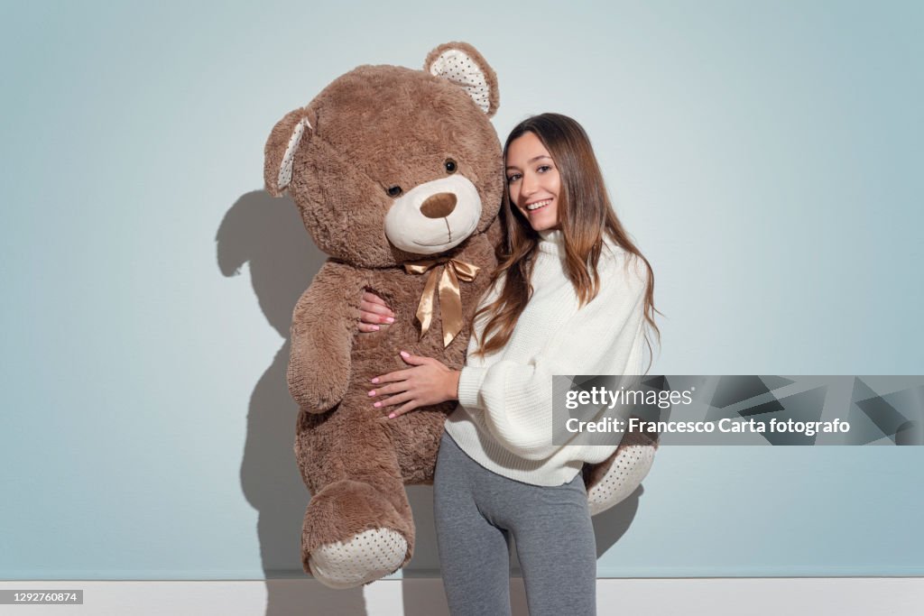 Young woman with large big teddy bear