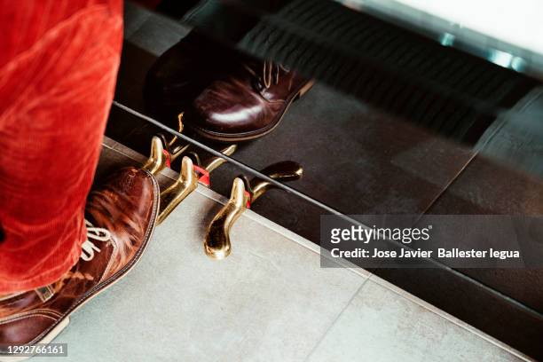 close-up of a pianist's feet in red corduroy trousers and brown leather shoes with laces playing the golden pedals of a black lacquered piano. reflections - orchestra pit stockfoto's en -beelden