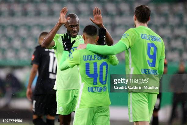Joao Victor of Vlf Wolfsburg celebrates with team mates Josuha Guilavogui and Wout Weghorst after scoring their sides third goal during the DFB Cup...