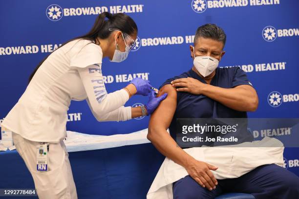 Leonida Lipshy, RN in the COVID unit at the Broward Health Medical Center, gives Jaime Carrillo, M.D. Internal Medicine, Broward Health Imperial...