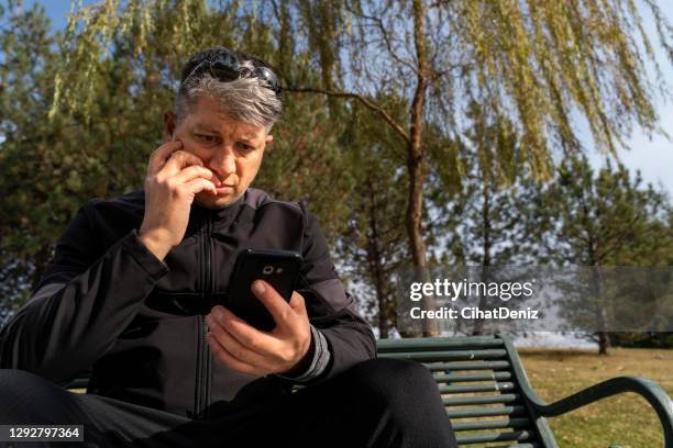 man looking at mobile phone worried - nail biting stock pictures, royalty-free photos & images