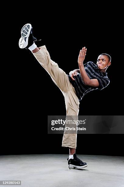 boy doing a high side kick - karate stock-fotos und bilder