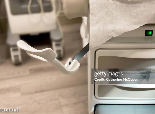 generic medical examination table & close-up of foot stirrup - stirrup stock pictures, royalty-free photos & images