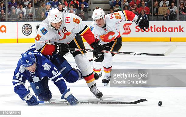 Nikolai Kulemin of the Toronto Maple Leafs is checked by Mark Giordano of the Calgary Flames during NHL game action October 15, 2011 at Air Canada...