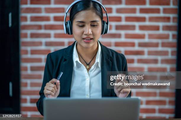 woman teacher wear wireless headset video calling on laptop - übersetzung stock-fotos und bilder