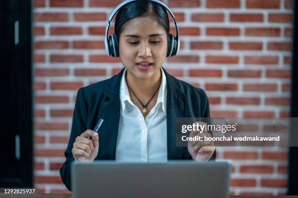 woman teacher wear wireless headset video calling on laptop - work video call stock pictures, royalty-free photos & images