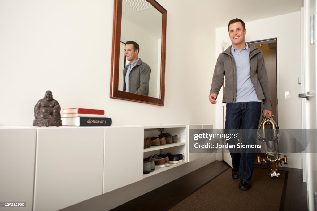 Man walking with a folding bike.