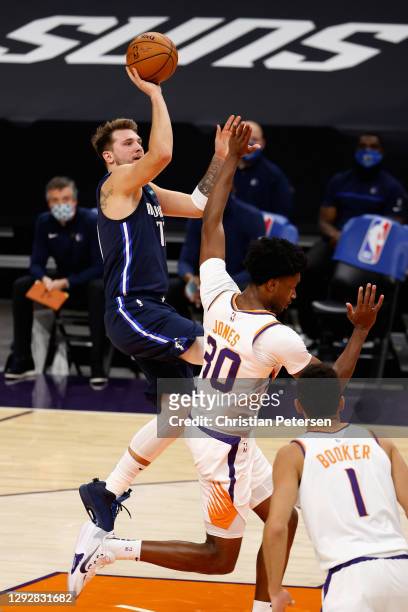Luka Doncic of the Dallas Mavericks attempts a shot over Damian Jones of the Phoenix Suns during the first half of the NBA game at PHX Arena on...
