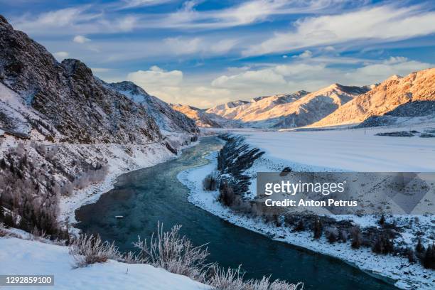 sunset in the winter mountains. katun river, altai, russia - summits russia 2015 fotografías e imágenes de stock