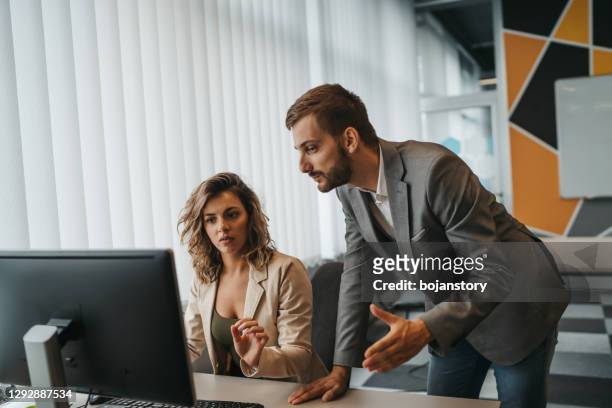 male and female office employees having argument at workplace - criticus stock pictures, royalty-free photos & images