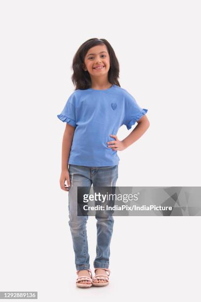 happy young girl standing with a hand on her waist. (children) - charmig bildbanksfoton och bilder