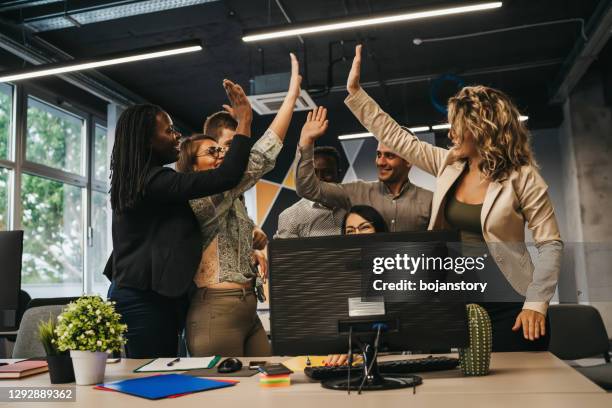 collègues multinationaux heureux donnant le haut cinq célébrant le grand résultat de travail d’équipe - business awards photos et images de collection