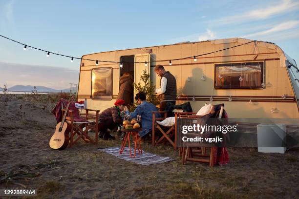 gruppe von freunden organisieren silvesterparty vor ihrem camper-trailer - caravan stock-fotos und bilder
