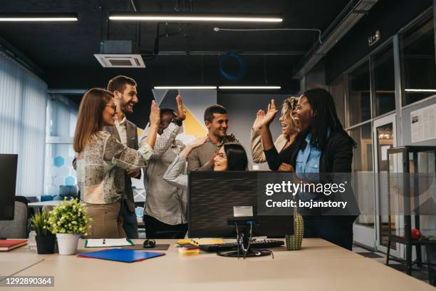 felizes colegas multinacionais dando high five celebrando grande resultado de trabalho em equipe - team usa awards - fotografias e filmes do acervo