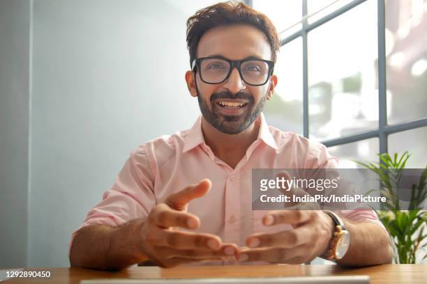 man gesturing while talking on video call - office cabin stockfoto's en -beelden