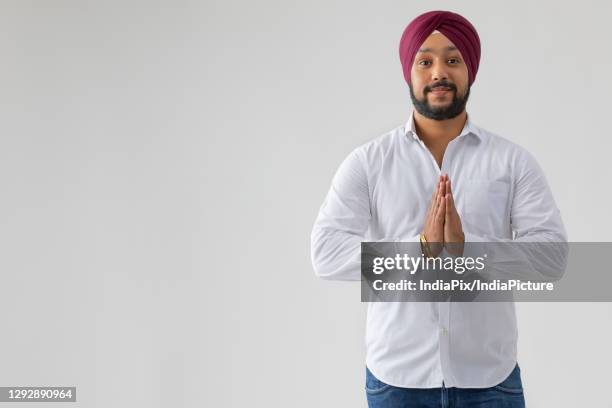 a sikh man greeting with folded hands - modern tradition stock pictures, royalty-free photos & images