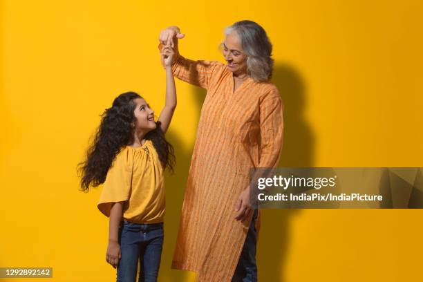 portrait of a happy grandmother dancing with her grand-daughter. - granddaughter foto e immagini stock