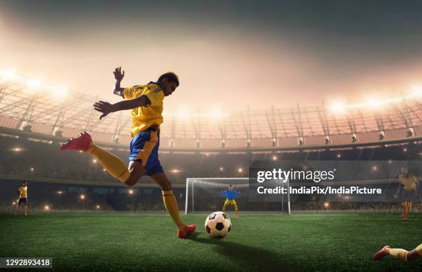 football player shooting the ball at the goal. - indian football stock pictures, royalty-free photos & images