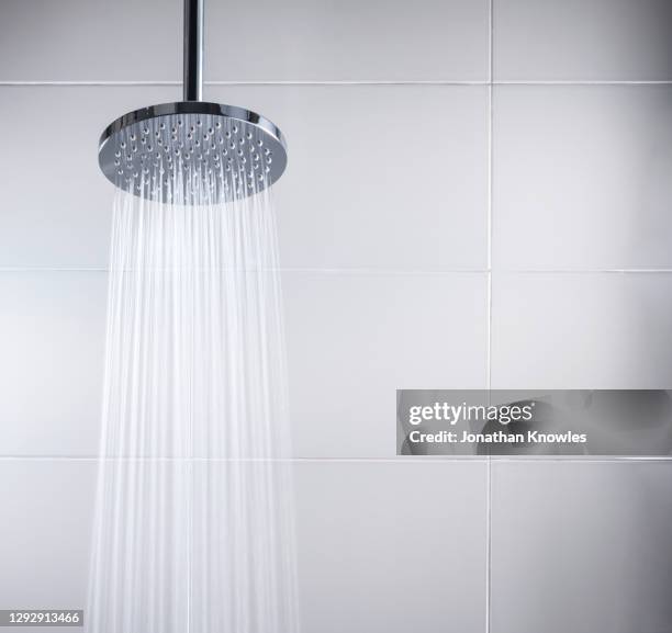 modern shower head - men taking a shower stockfoto's en -beelden