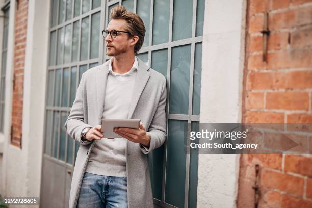 stilig gentleman som använder tablett på gatan - modern manlighet bildbanksfoton och bilder