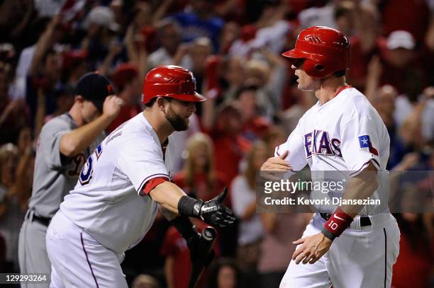 Michael Young of the Texas Rangers celebrates with Mike Napoli after scoring to take a 3-2 lead in the third inning of Game Six of the American...